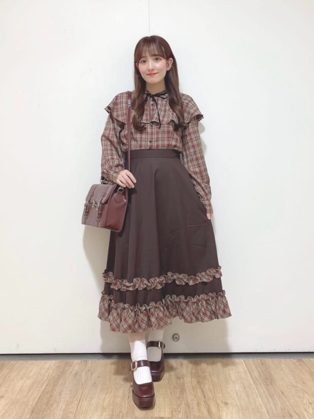 ブラウン系のパンプス、ブラウン系のショルダーバッグ、ブラウン系のシャツ/ブラウスを着用したレディースの秋コーディネートの1枚目の写真