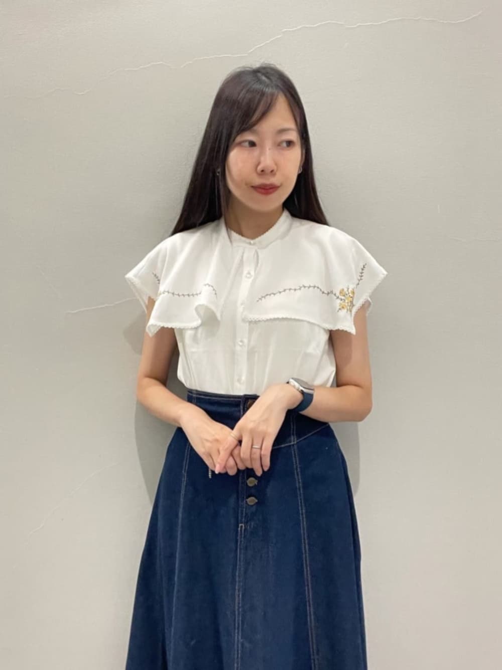 ホワイト系のパンプス、ホワイト系のシャツ/ブラウス、ブルー系のデニムスカートを着用したレディースの夏コーディネートの1枚目の写真