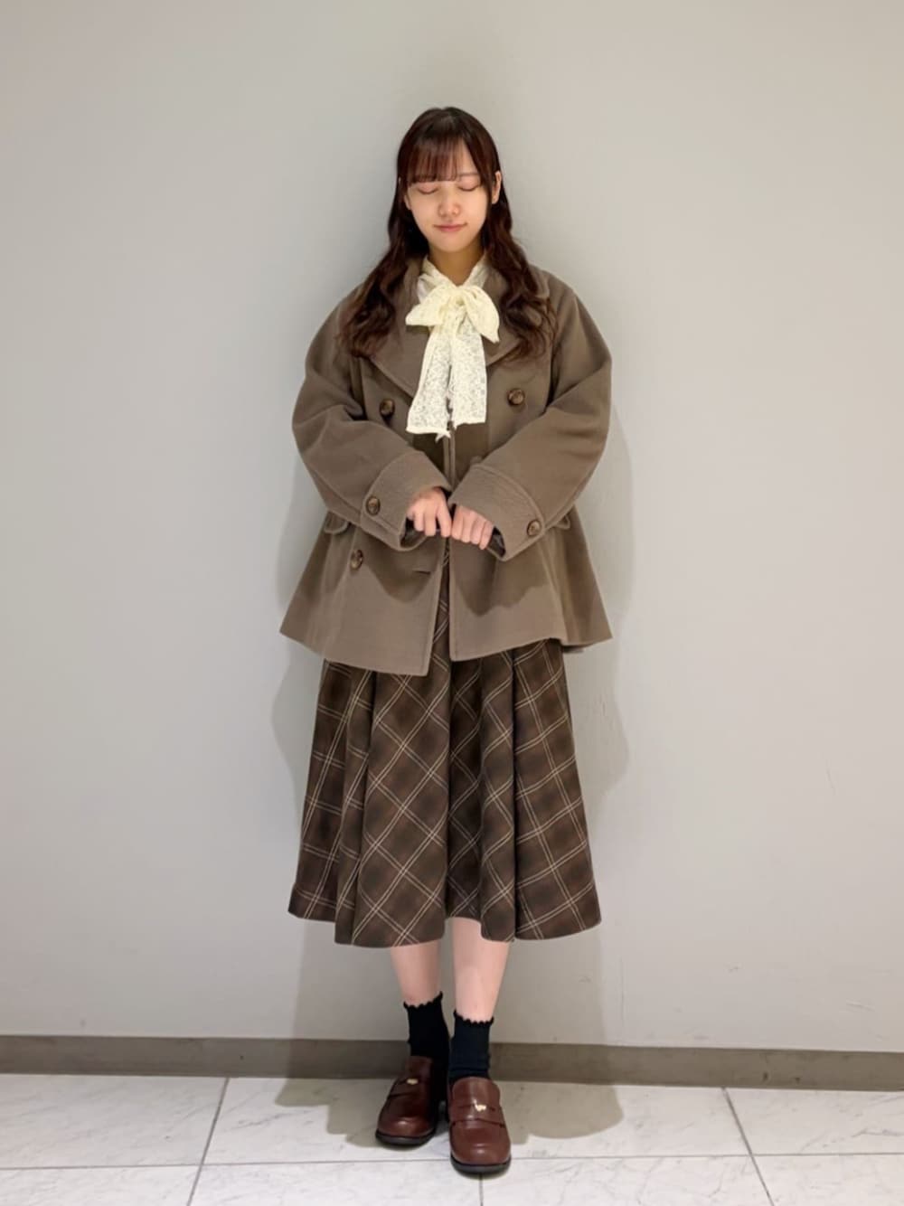 ブラウン系のローファー、ホワイト系のシャツ/ブラウス、ブラウン系のピーコートを着用したレディースの冬コーディネートの1枚目の写真