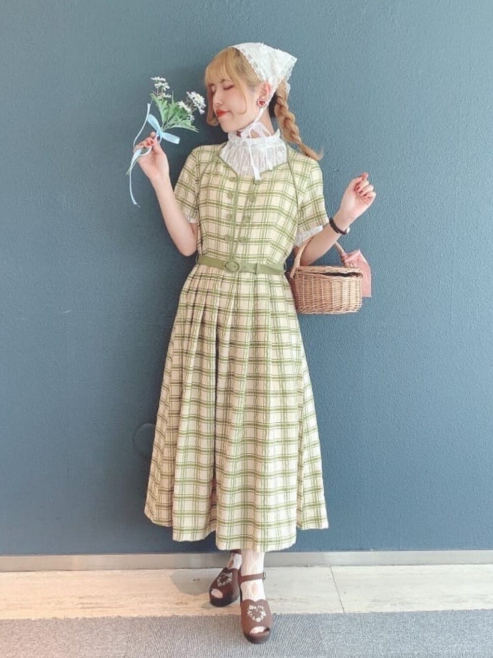 グリーン系のワンピース、ブラウン系のサンダル、ホワイト系のTシャツ/カットソーを着用したレディースの春コーディネートの1枚目の写真