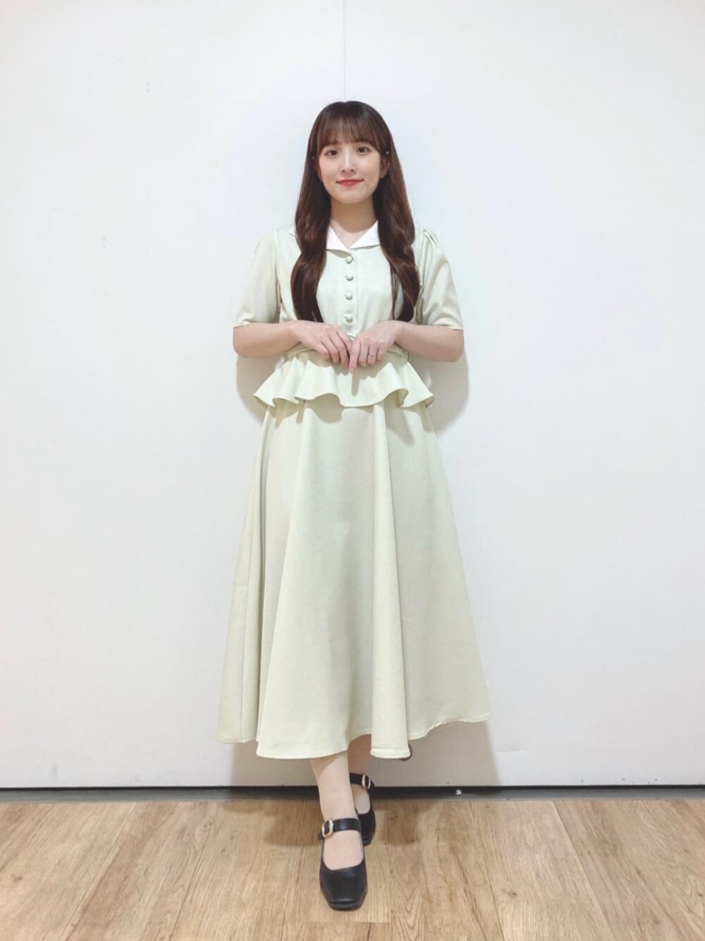 ブラック系のパンプス、グリーン系のワンピースを着用したレディースの夏コーディネートの1枚目の写真