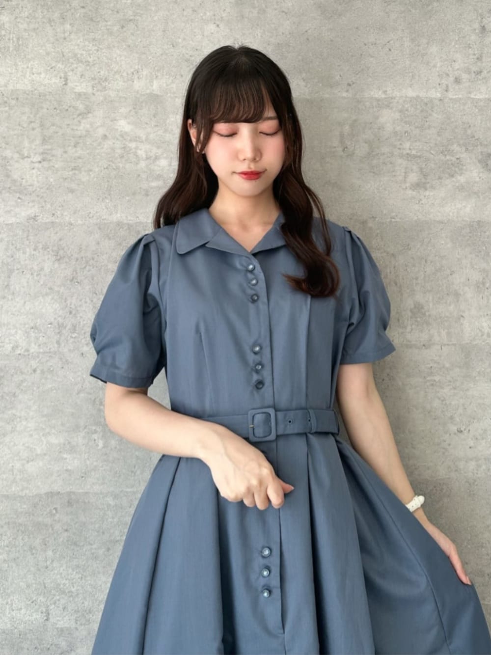 ブラック系のパンプス、ブルー系のシャツワンピース、ブラック系のハンドバッグを着用したレディースの夏コーディネートの1枚目の写真