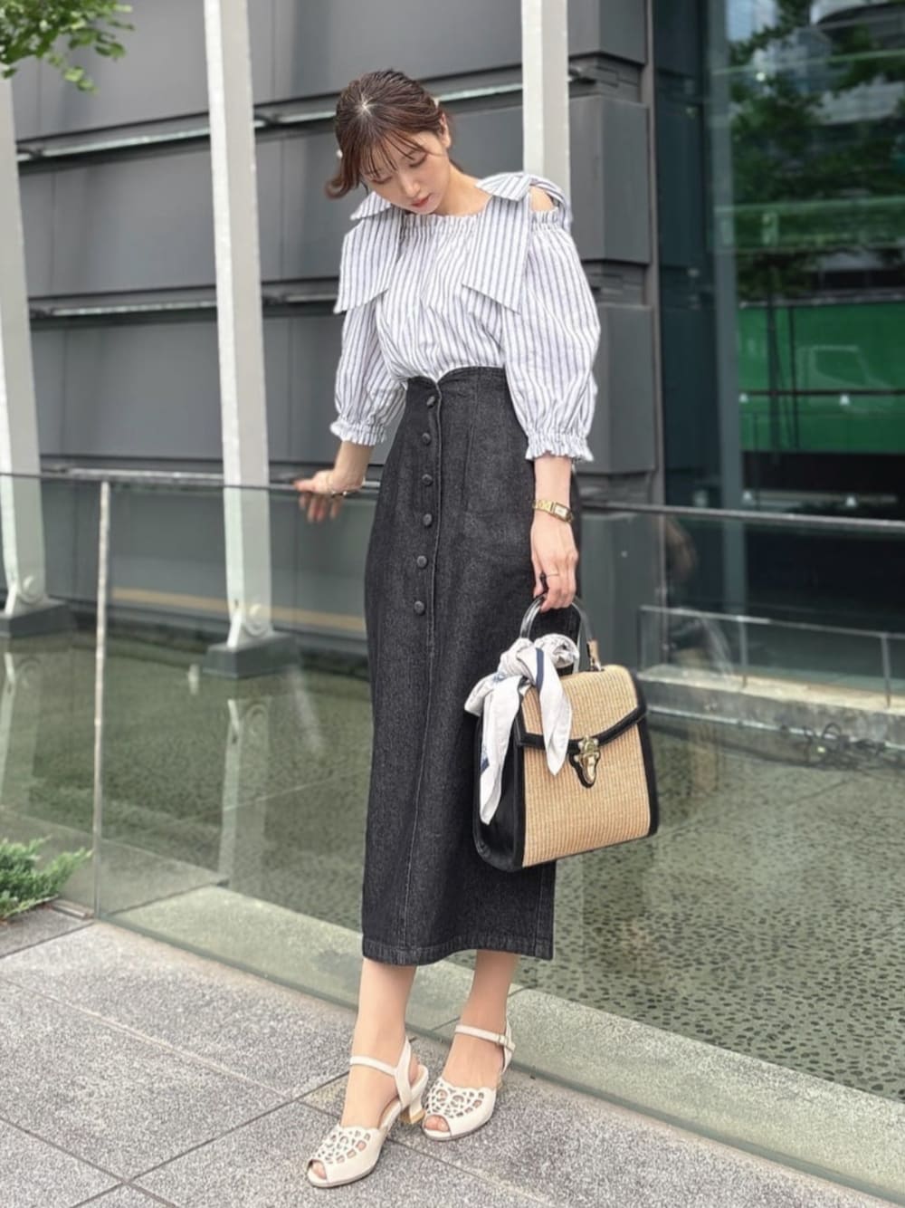 ブラック系のハンドバッグ、ホワイト系のサンダル、ホワイト系のシャツ/ブラウスを着用したレディースの夏コーディネートの1枚目の写真