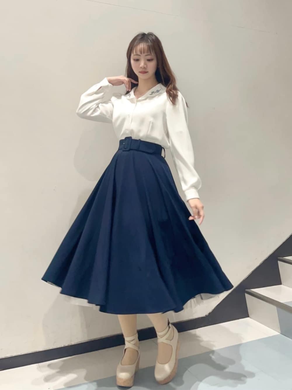 ホワイト系のパンプス、ブルー系のスカート、ホワイト系のシャツ/ブラウスを着用したレディースの冬コーディネートの1枚目の写真