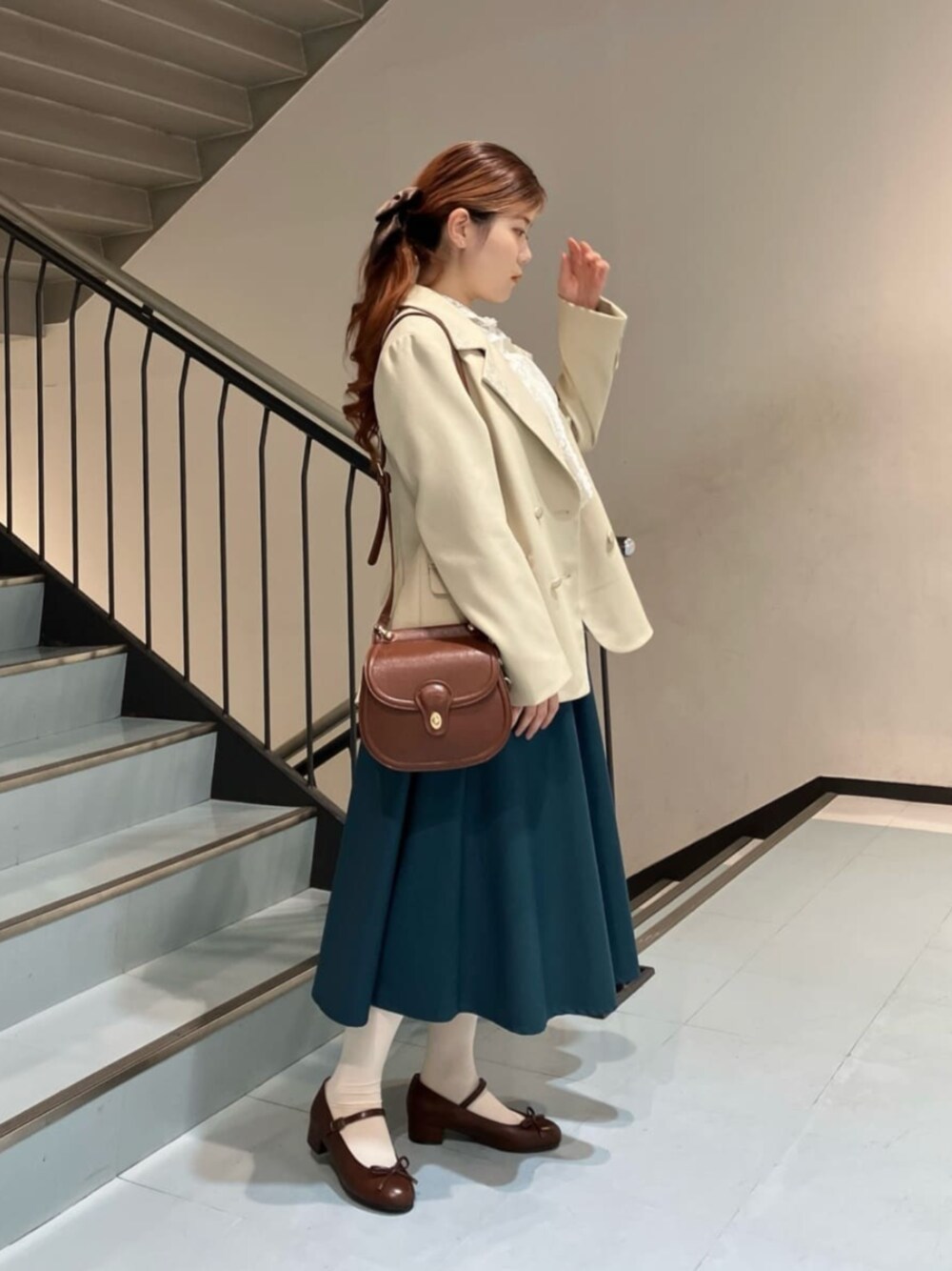 ブラウン系のパンプス、ホワイト系のシャツ/ブラウス、ブラウン系のショルダーバッグを着用したレディースの冬コーディネートの1枚目の写真