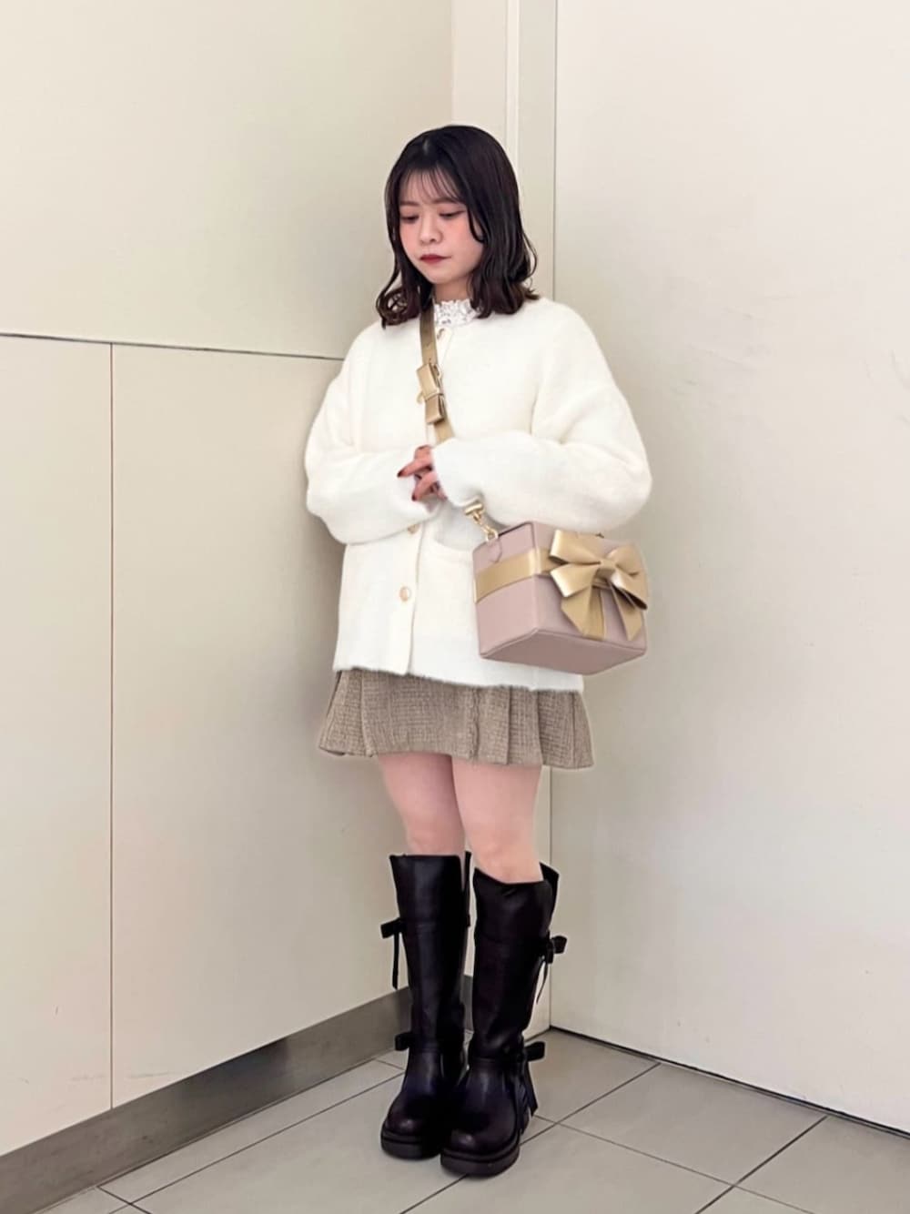 ホワイト系のTシャツ/カットソー、ブラウン系のブーツ、ホワイト系のカーディガン/ボレロを着用したレディースの秋コーディネートの1枚目の写真