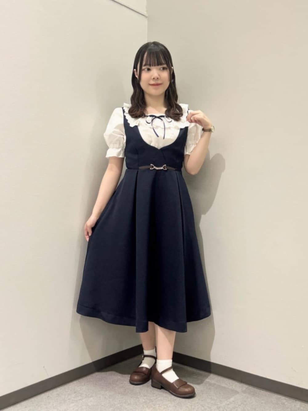 ブラウン系のローファー、ブルー系のジャンパースカート、ホワイト系のシャツ/ブラウスを着用したレディースの夏コーディネートの1枚目の写真