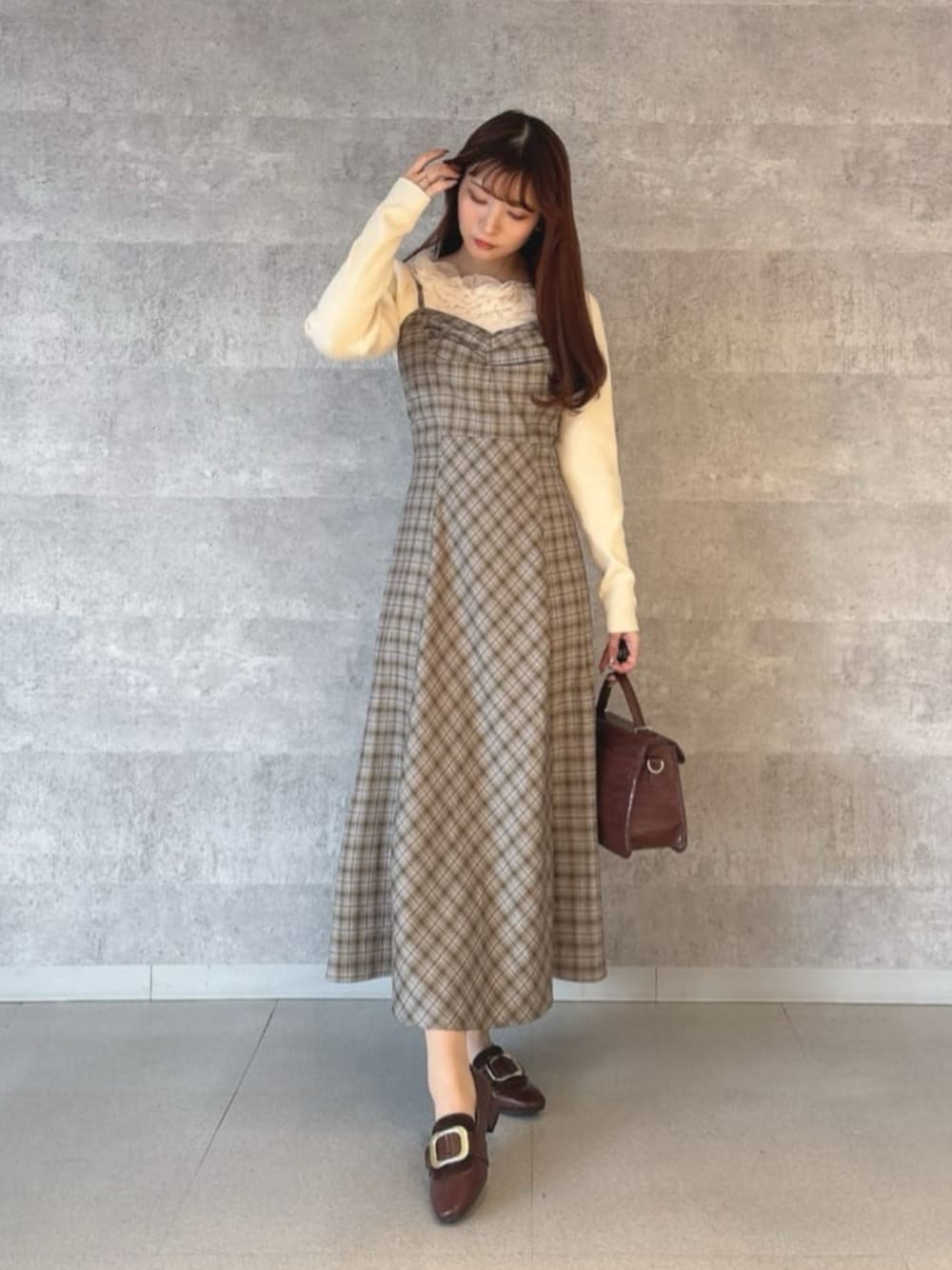 ブラウン系のその他シューズ、イエロー系のハンドバッグ、グレー系のワンピースを着用したレディースの冬コーディネートの1枚目の写真