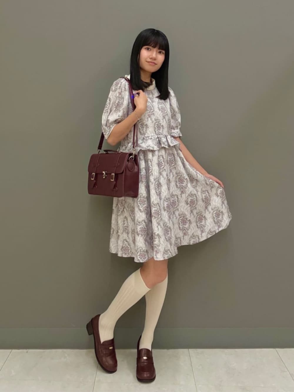 ブラウン系のローファー、ブラウン系のショルダーバッグ、ピンク系のワンピースを着用したレディースの夏コーディネートの1枚目の写真