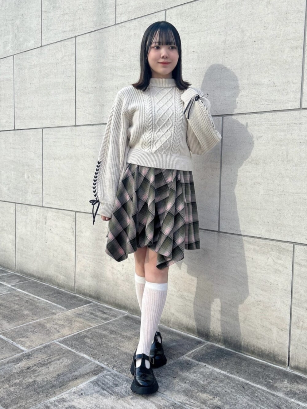 ブラック系のその他シューズ、グリーン系のスカート、ホワイト系のニット/セーターを着用したレディースの冬コーディネートの1枚目の写真