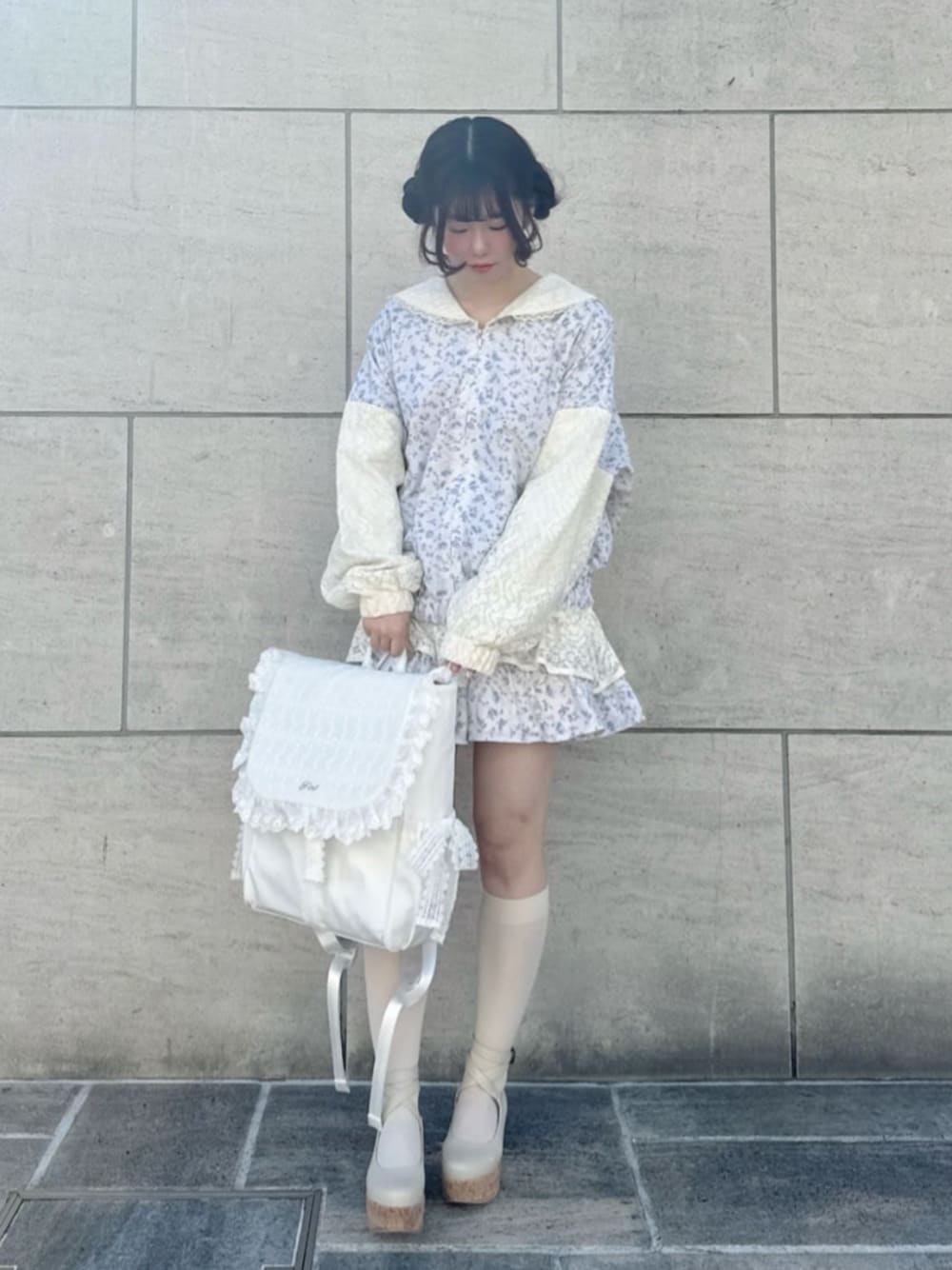 ホワイト系のパンプス、ホワイト系のブルゾン、ホワイト系のスカートを着用したレディースの冬コーディネートの1枚目の写真