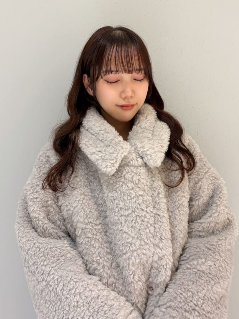 ブラック系のハンドバッグ、ブラウン系のモカシン/デッキシューズ、ブラック系のデニムパンツを着用したレディースの冬コーディネートの1枚目の写真