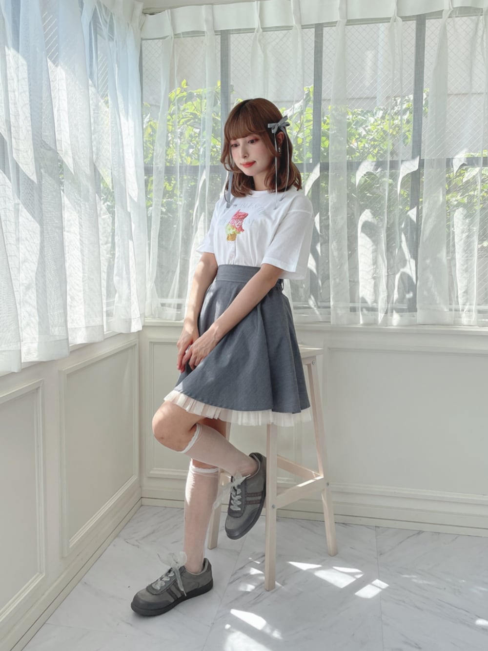 グレー系のスニーカー、グレー系のスカート、グレー系のバレッタ/ヘアクリップを着用したレディースの夏コーディネートの1枚目の写真