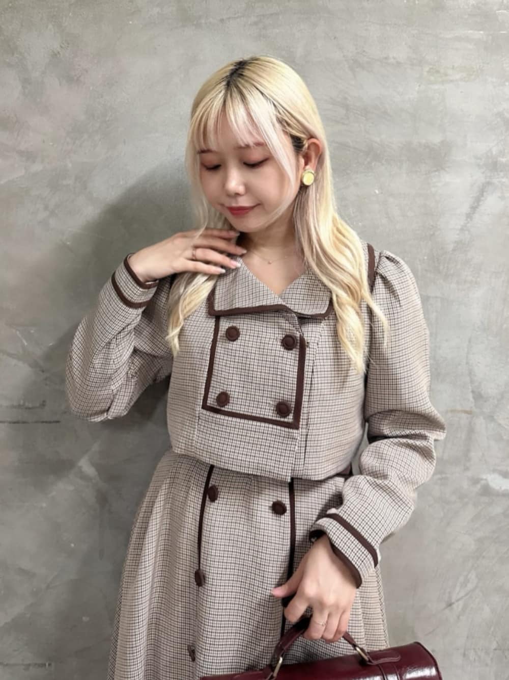 ブラウン系のショルダーバッグ、レッド系のパンプス、ベージュ系のセットアップを着用したレディースの秋コーディネートの1枚目の写真