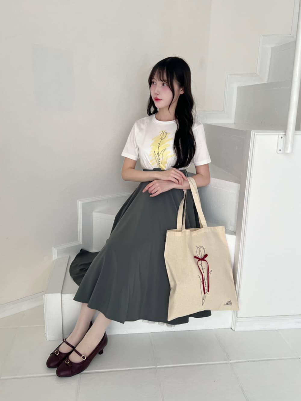 グリーン系のスカート、イエロー系のTシャツ/カットソーを着用したレディースの夏コーディネートの1枚目の写真