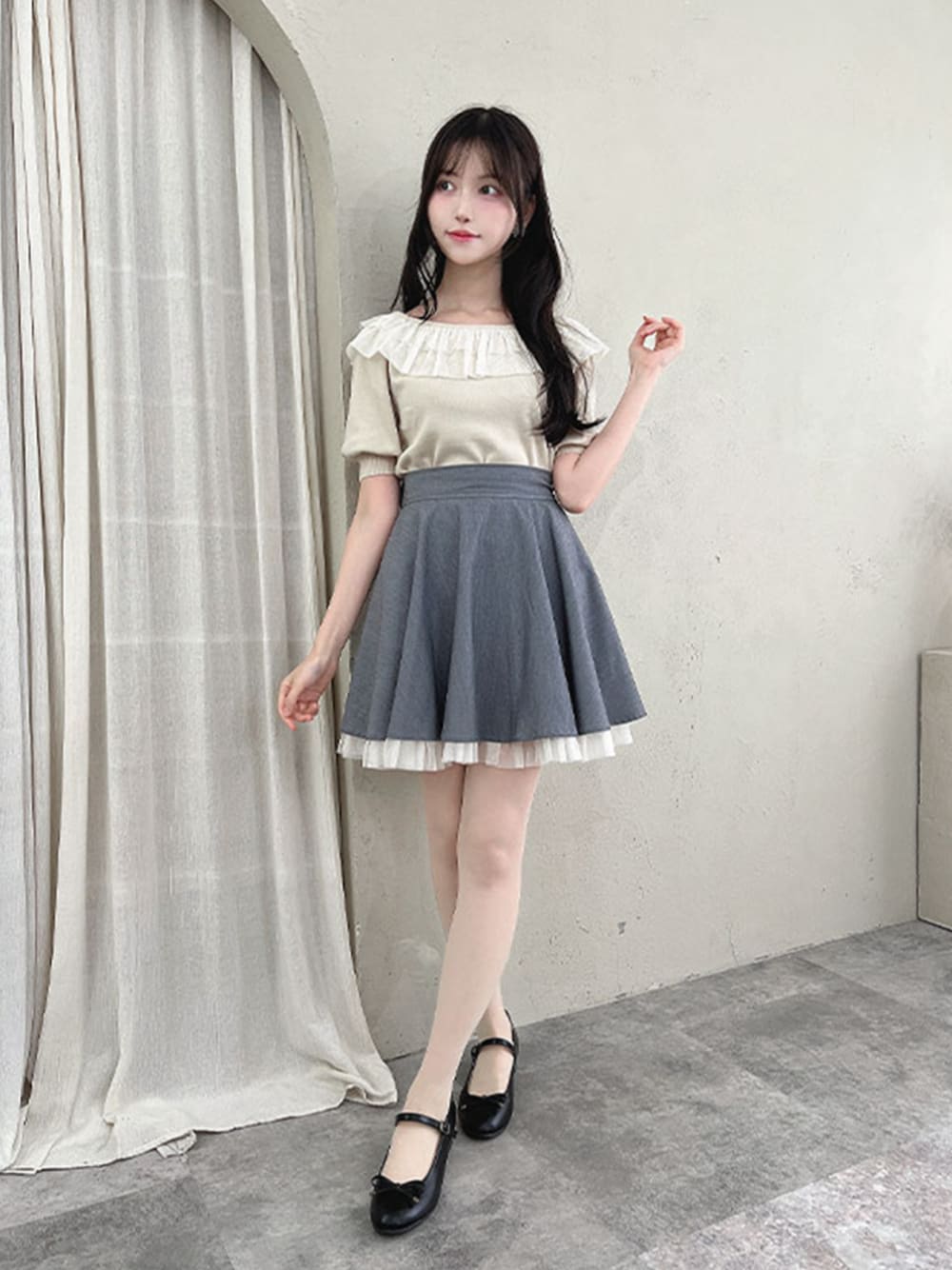 ブラック系のパンプス、グレー系のスカート、ホワイト系のニット/セーターを着用したレディースの夏コーディネートの1枚目の写真