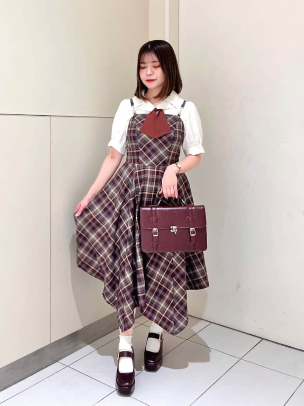 ブラウン系のパンプス、ブラウン系のショルダーバッグ、ホワイト系のシャツ/ブラウスを着用したレディースの夏コーディネートの1枚目の写真