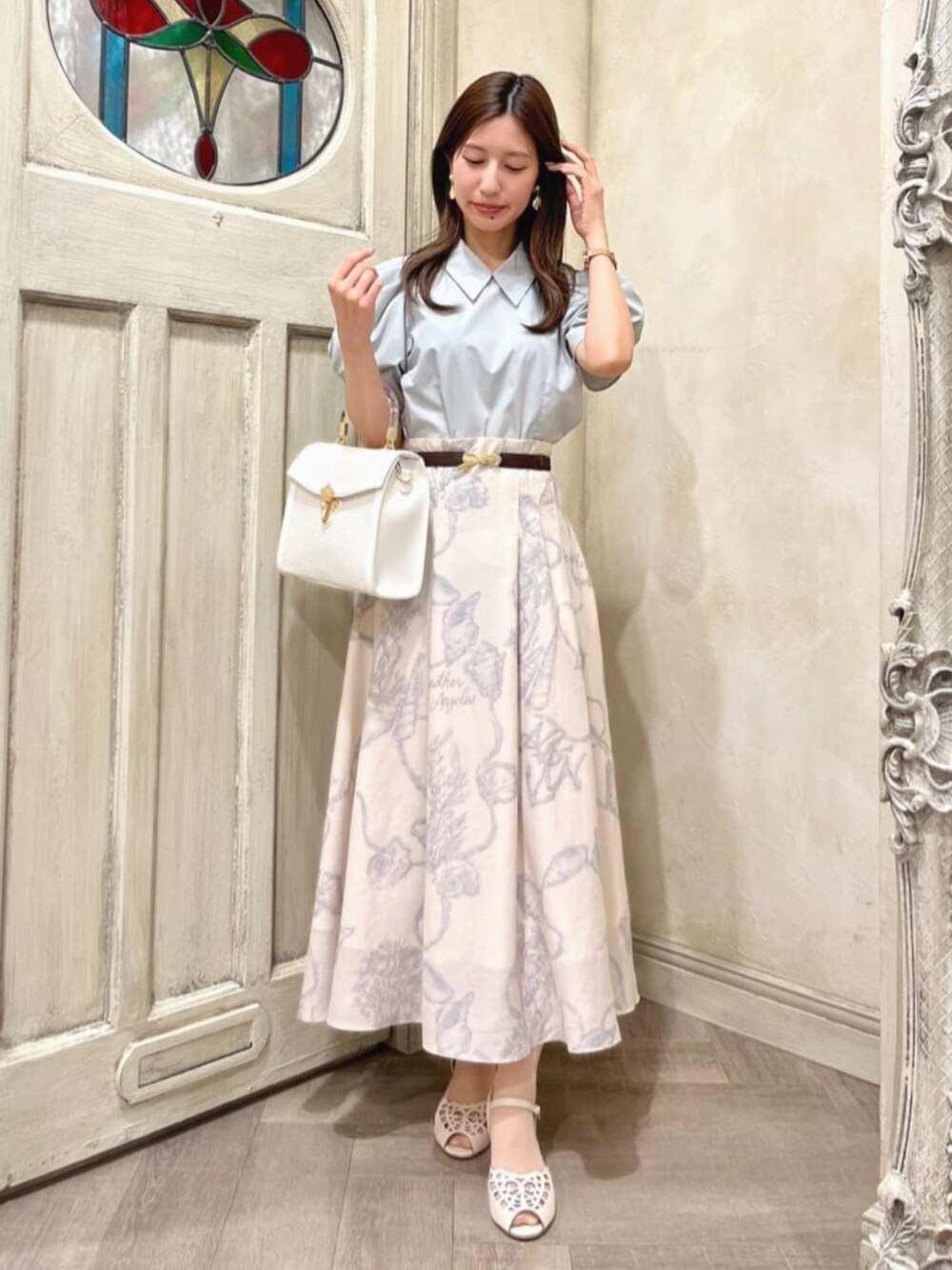 ホワイト系のハンドバッグ、ホワイト系のサンダル、グリーン系のシャツ/ブラウスを着用したレディースの夏コーディネートの1枚目の写真