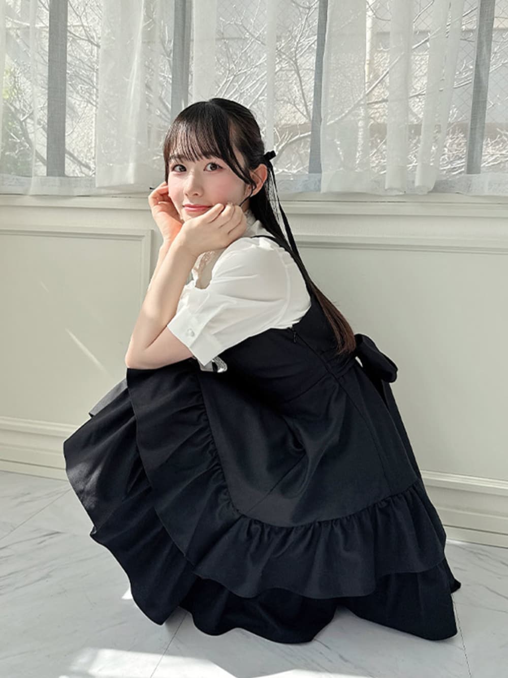 ベージュ系のバレエシューズ、ホワイト系のシャツ/ブラウス、ブラック系のジャンパースカートを着用したレディースの春コーディネートの1枚目の写真