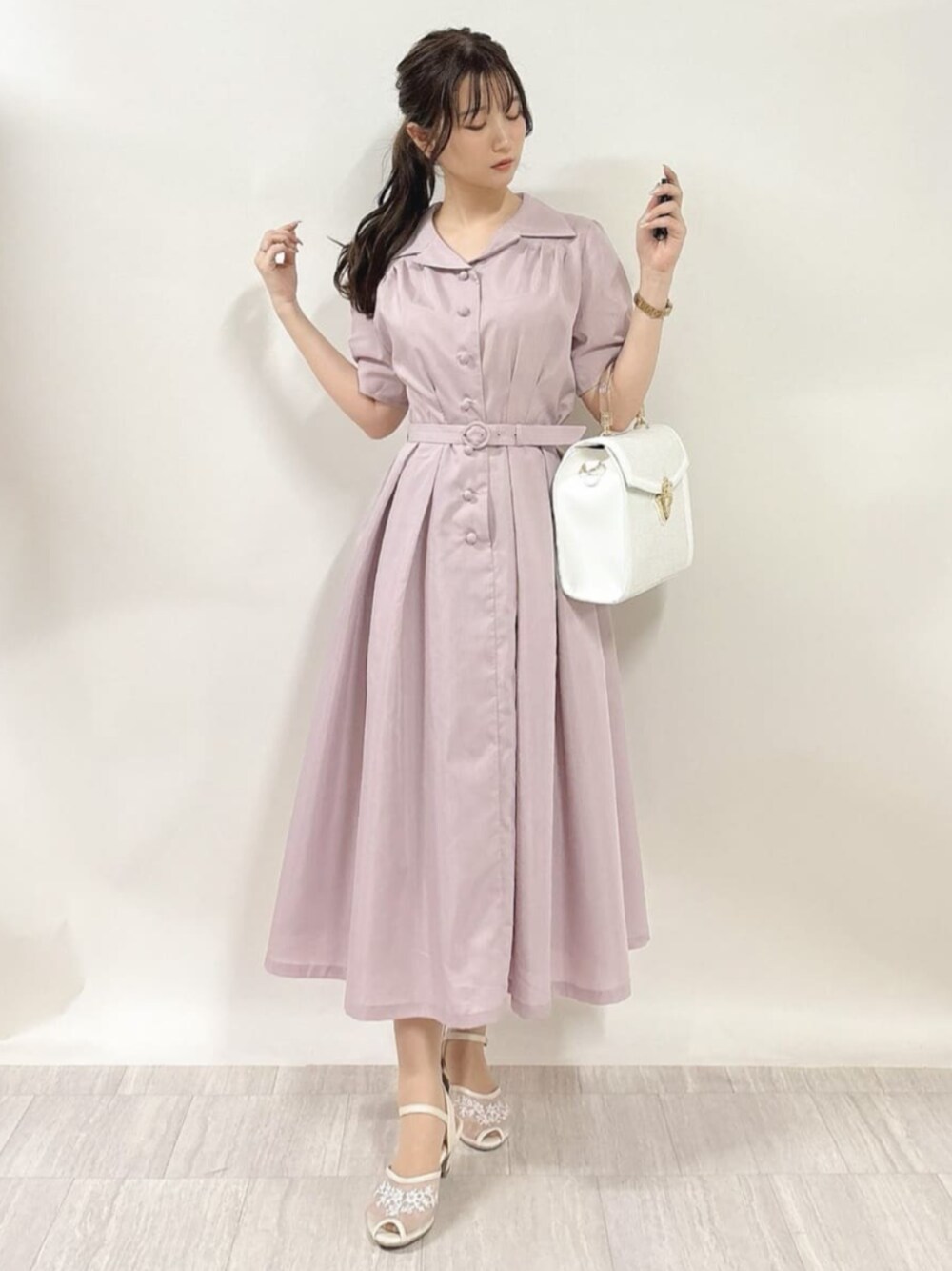 ホワイト系のサンダル、ホワイト系のハンドバッグ、ピンク系のワンピースを着用したレディースの春コーディネートの1枚目の写真