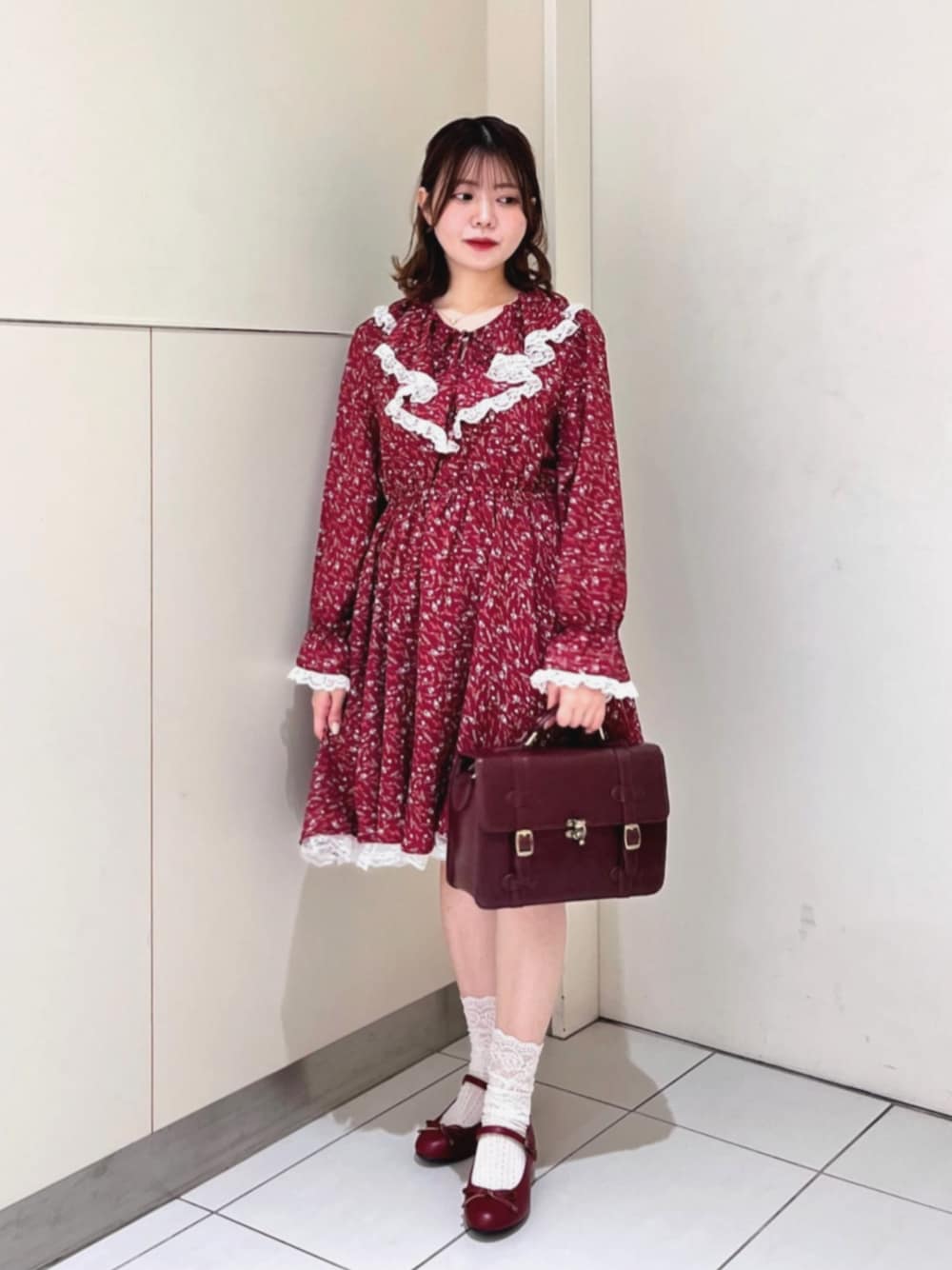 ブラウン系のショルダーバッグ、レッド系のワンピース、レッド系のバレエシューズを着用したレディースの秋コーディネートの1枚目の写真