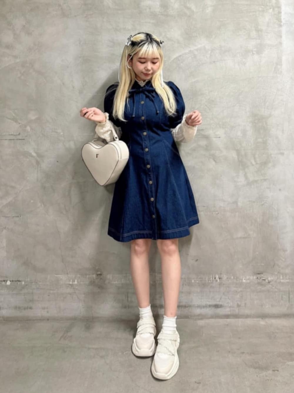 ホワイト系のスニーカー、ホワイト系のハンドバッグ、ブルー系のワンピースを着用したレディースの春コーディネートの1枚目の写真