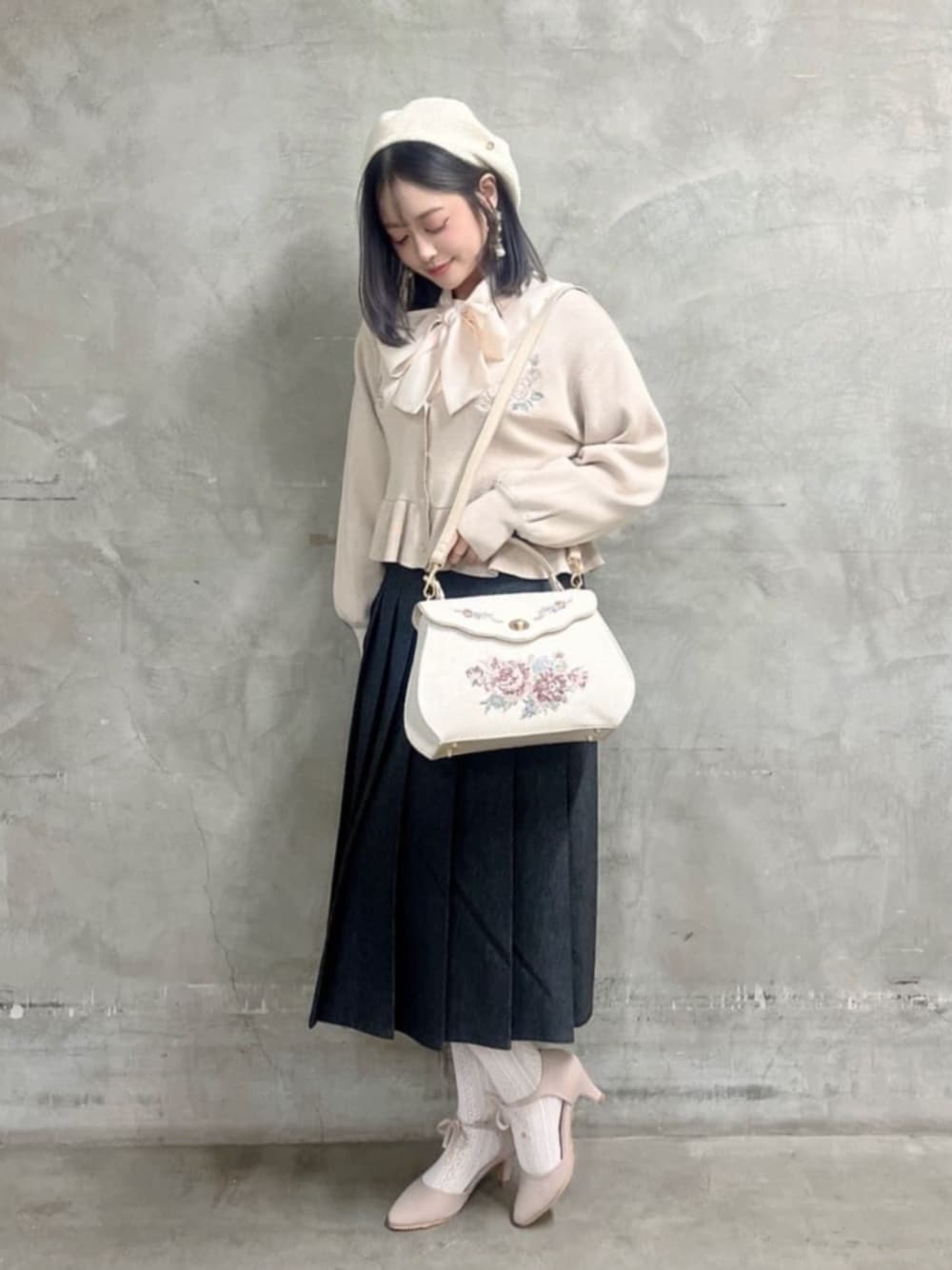 ブラック系のデニムスカート、ピンク系のシャツ/ブラウス、ホワイト系のハンドバッグを着用したレディースの冬コーディネートの1枚目の写真