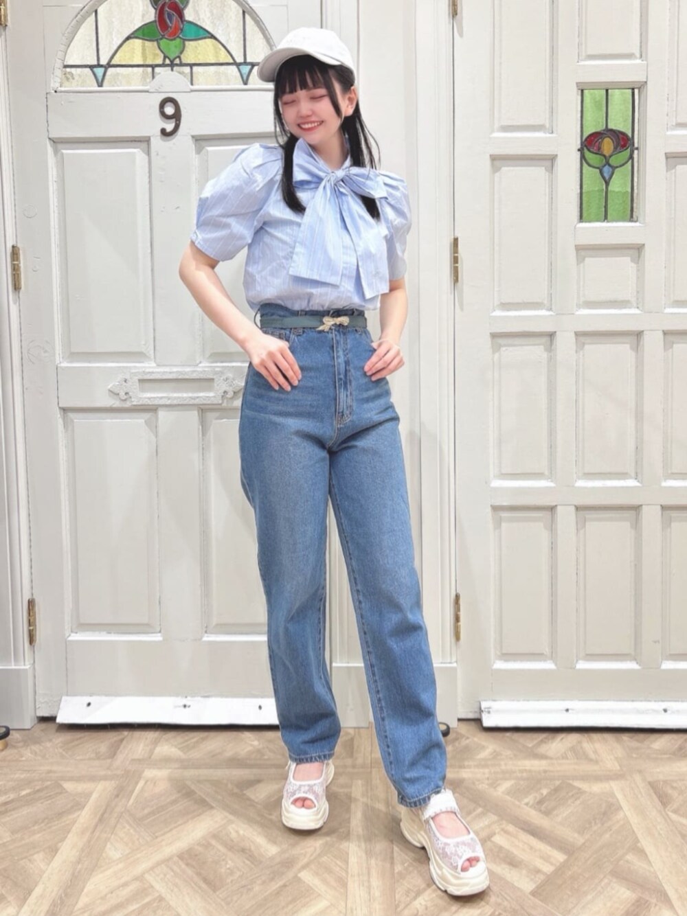 ホワイト系のスニーカー、ブルー系のシャツ/ブラウス、ブルー系のデニムパンツを着用したレディースの春コーディネートの1枚目の写真