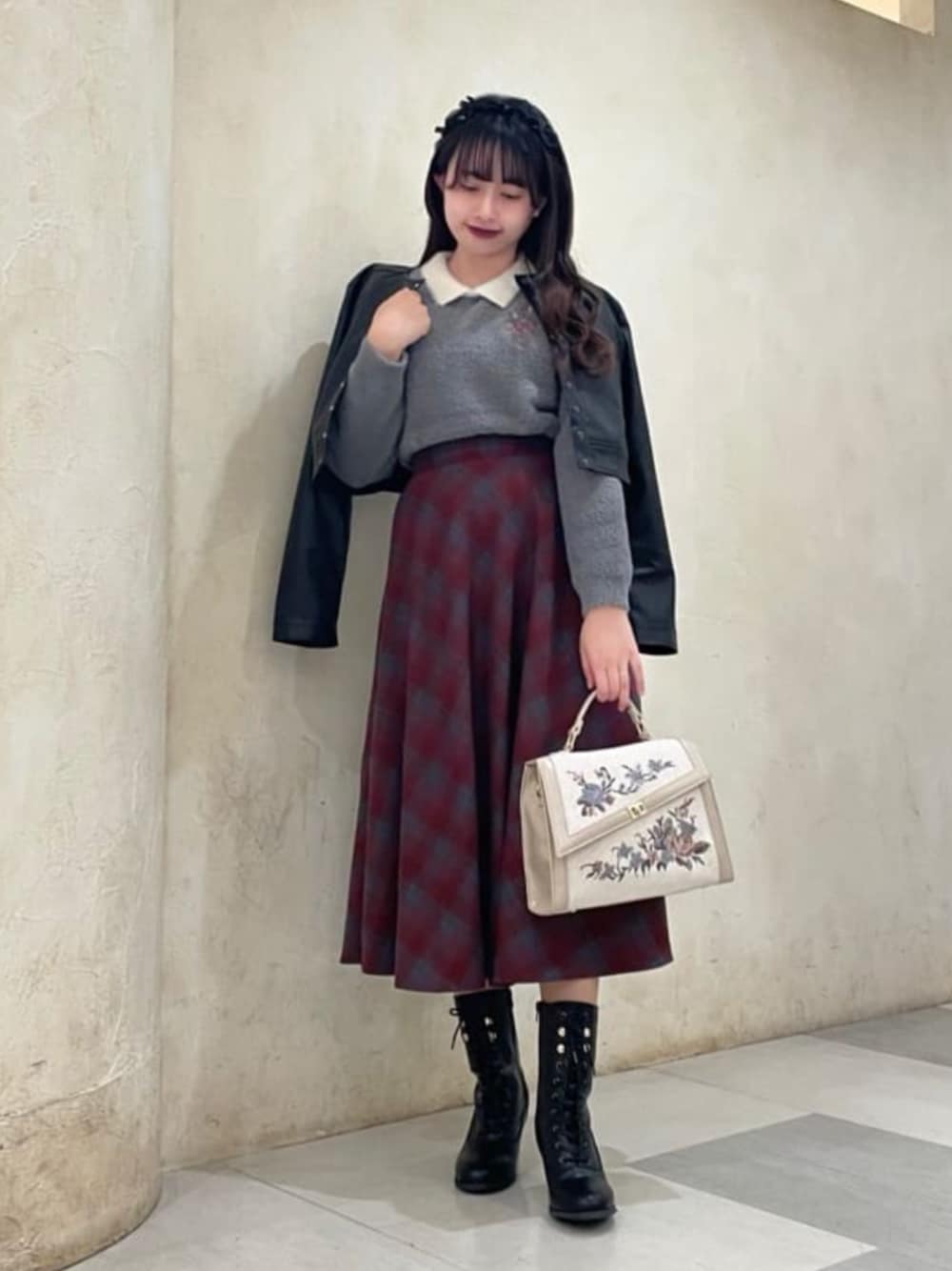 ブラック系のライダースジャケット、レッド系のスカート、グレー系のニット/セーターを着用したレディースの秋コーディネートの1枚目の写真