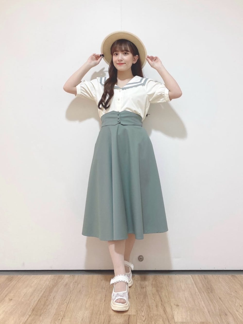 グリーン系のスカート、ホワイト系のサンダル、ホワイト系のシャツ/ブラウスを着用したレディースの夏コーディネートの1枚目の写真