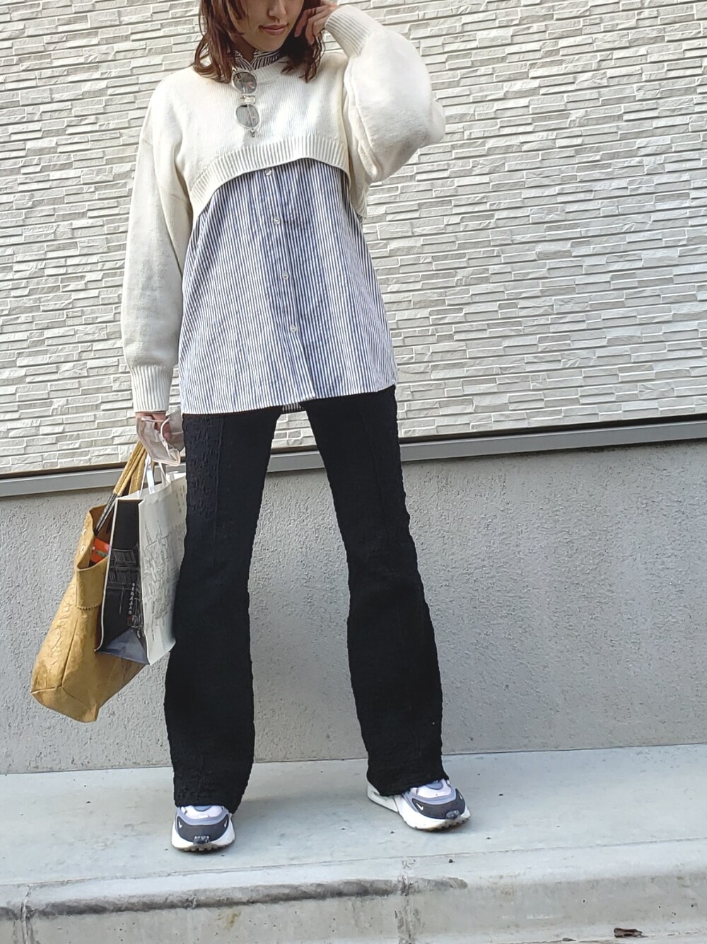 ホワイト系のニット/セーター、グレー系のシャツ/ブラウス、ベージュ系のトートバッグを着用したレディースの春コーディネートの2枚目の写真