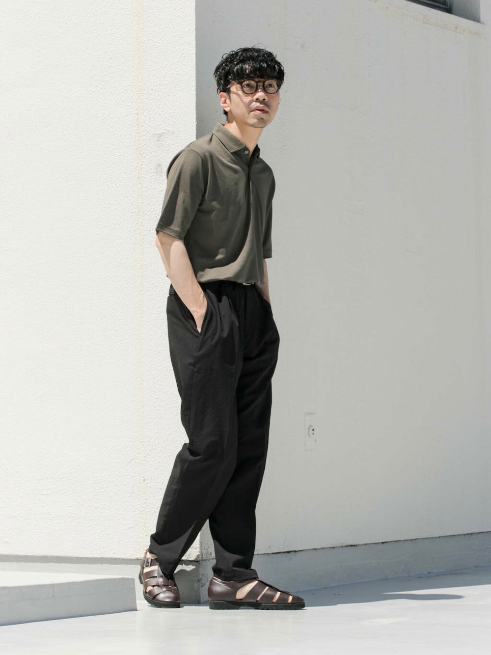 ブラック系のその他パンツ、グリーン系のポロシャツを着用したメンズの夏コーディネートの1枚目の写真