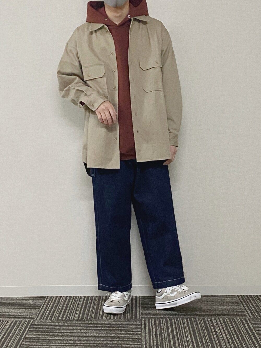 ベージュ系のブルゾン、ブラウン系のパーカー、ブルー系のデニムパンツを着用したメンズの春コーディネートの1枚目の写真