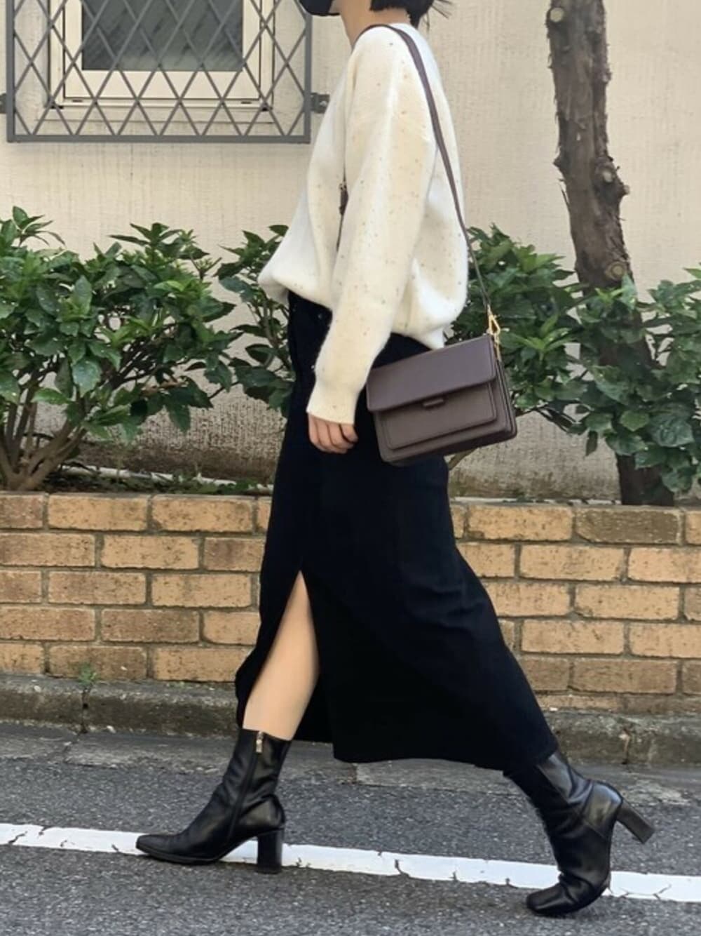 ホワイト系のニット/セーター、ブラック系のスカート、ブラウン系のショルダーバッグを着用したレディースの秋コーディネートの1枚目の写真
