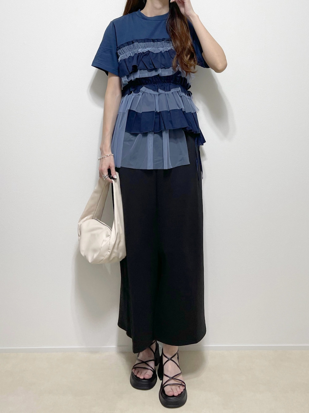 ブルー系のTシャツ/カットソー、ブラック系のスカート、ブラック系のサンダルを着用したレディースの夏コーディネートの1枚目の写真