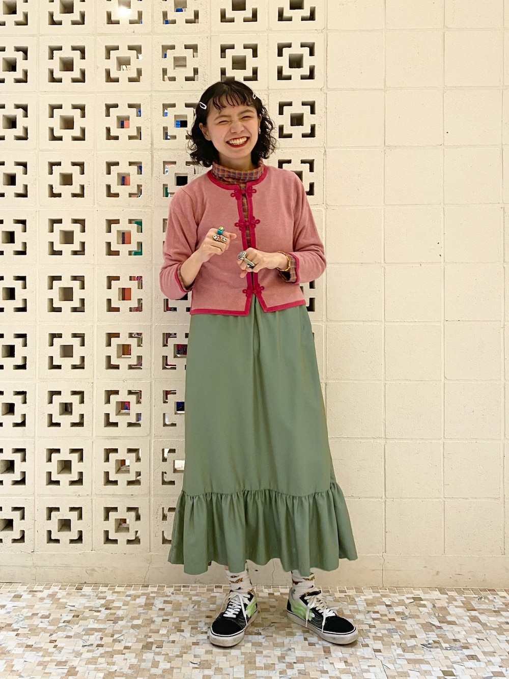 ブラック系のスニーカー、グリーン系のスカート、レッド系のTシャツ/カットソーを着用したレディースの夏コーディネートの1枚目の写真