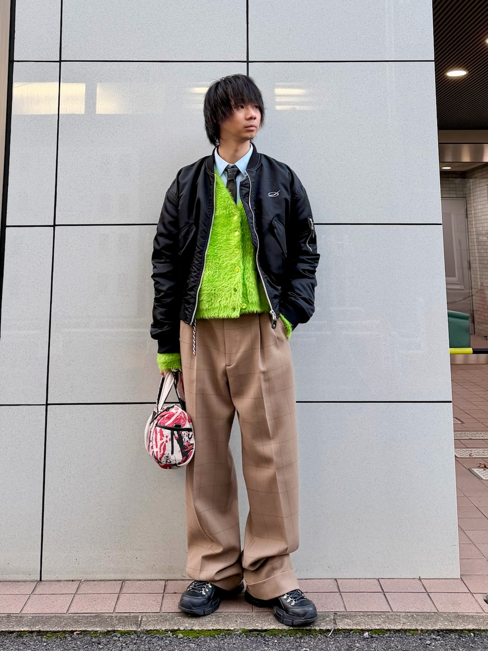 ベージュ系のスラックス、ブラック系のシューズ、ブラック系のMA-1を着用したメンズの秋コーディネートの1枚目の写真