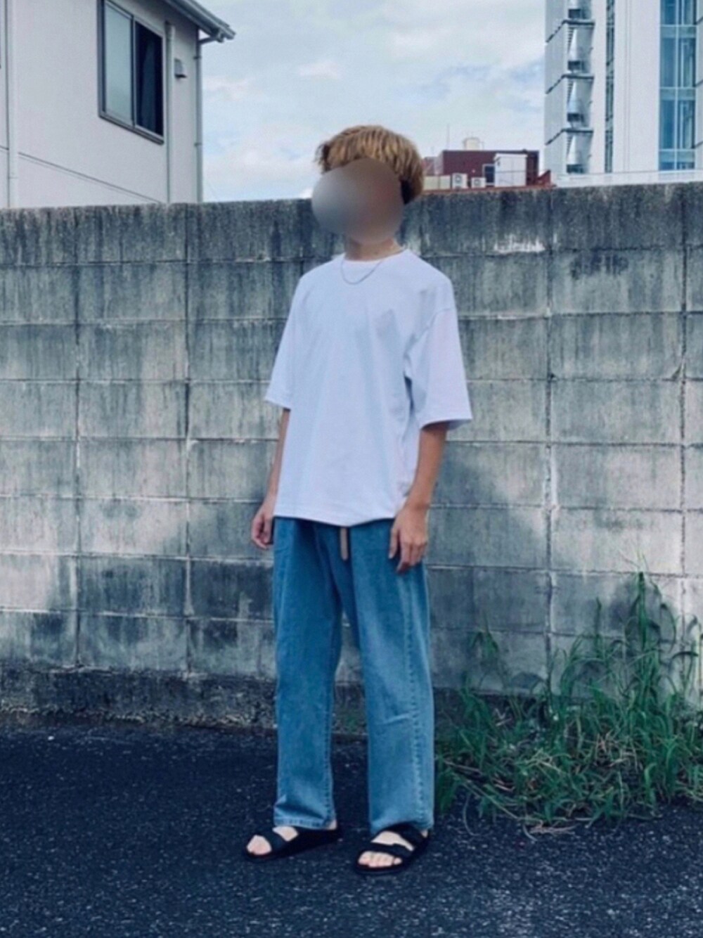ホワイト系のTシャツ/カットソー、ブルー系のデニムパンツ、ブラック系のサンダルを着用したメンズの夏コーディネートの1枚目の写真