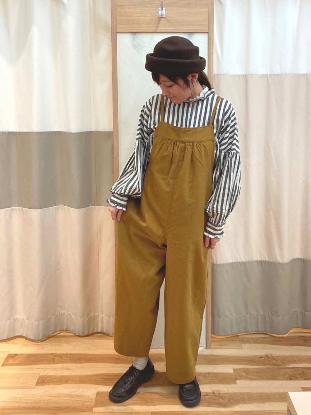 イエロー系のサロペット/オーバーオール、ブラック系のドレスシューズ、グレー系のシャツ/ブラウスを着用したレディースの秋コーディネートの1枚目の写真