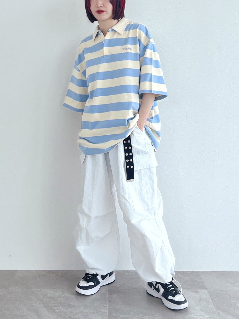 ブルー系のポロシャツ、ホワイト系のその他パンツ、ブラック系のベルトを着用したレディースの春コーディネートの3枚目の写真