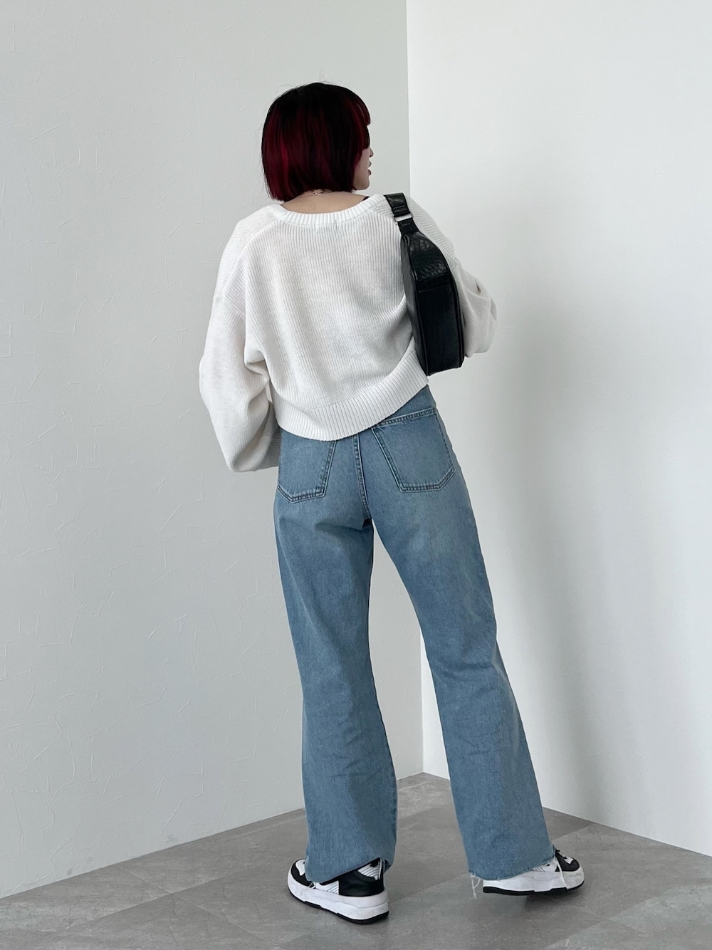 イエロー系のタンクトップ、ホワイト系のカーディガン/ボレロ、ブルー系のデニムパンツを着用したレディースの春コーディネートの3枚目の写真