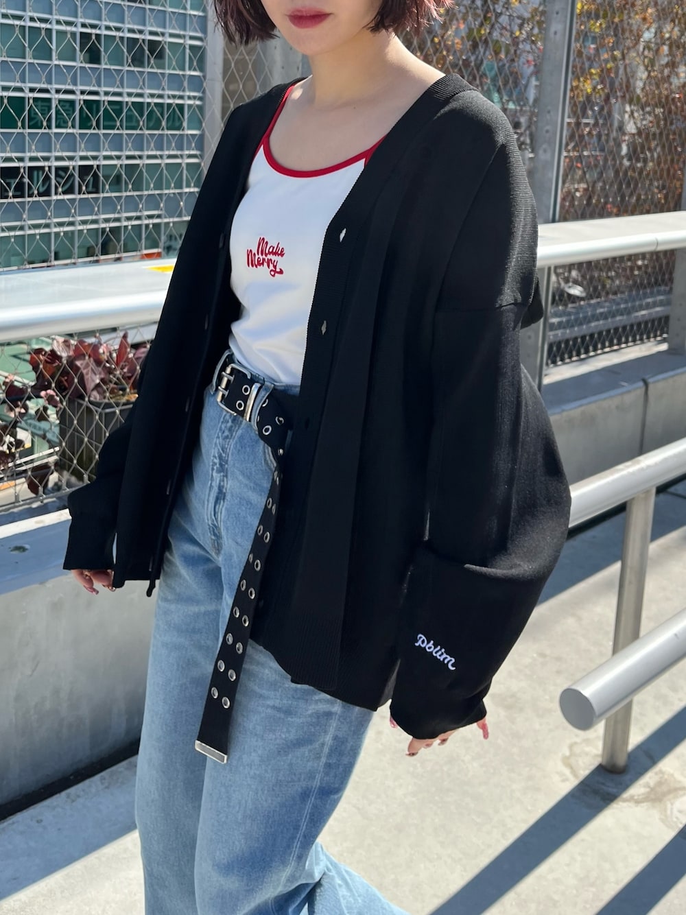 ホワイト系のキャミソール、ブラック系のカーディガン/ボレロ、ブルー系のデニムパンツを着用したレディースの春コーディネートの3枚目の写真