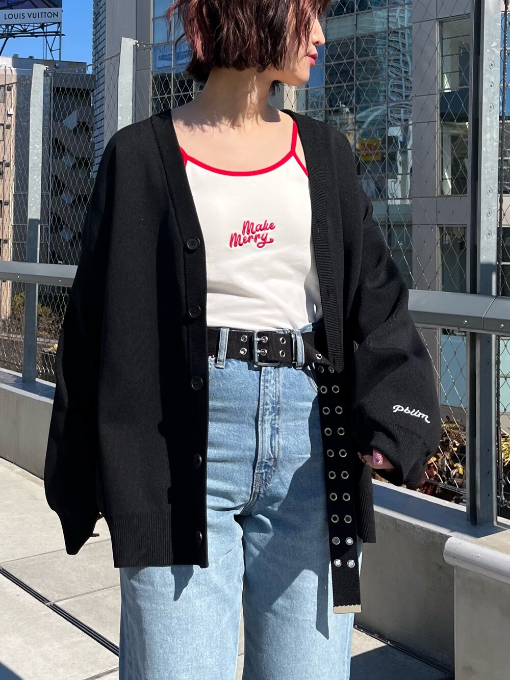 ホワイト系のキャミソール、ブラック系のカーディガン/ボレロ、ブルー系のデニムパンツを着用したレディースの春コーディネートの4枚目の写真
