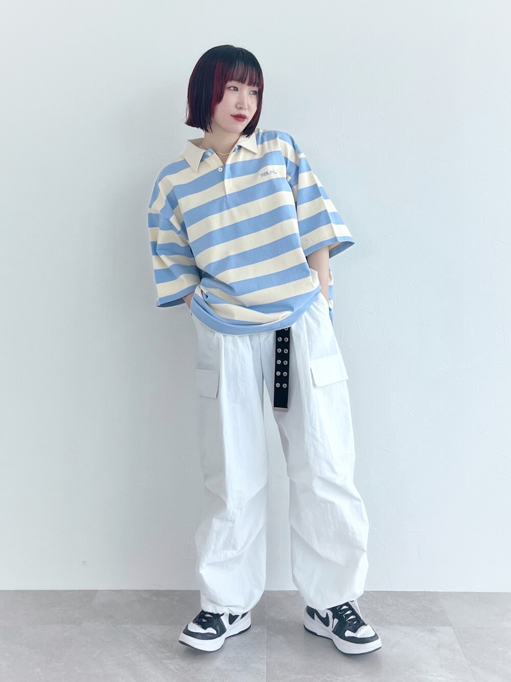 ブルー系のポロシャツ、ホワイト系のその他パンツ、ブラック系のベルトを着用したレディースの春コーディネートの4枚目の写真