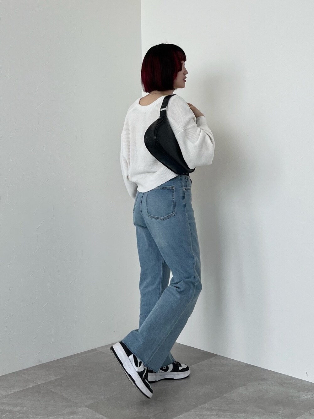 イエロー系のタンクトップ、ホワイト系のカーディガン/ボレロ、ブルー系のデニムパンツを着用したレディースの春コーディネートの2枚目の写真