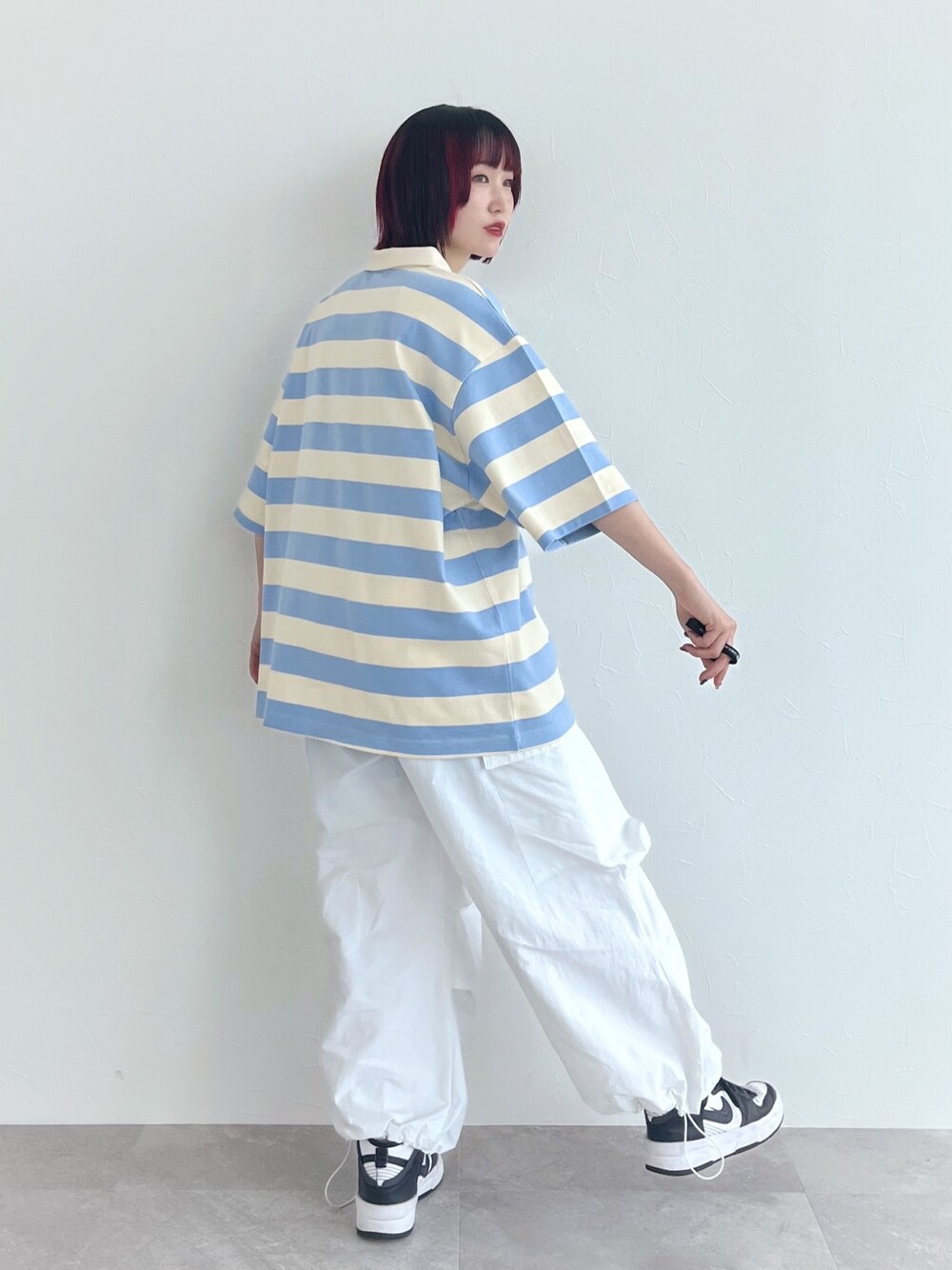 ブルー系のポロシャツ、ホワイト系のその他パンツ、ブラック系のベルトを着用したレディースの春コーディネートの2枚目の写真