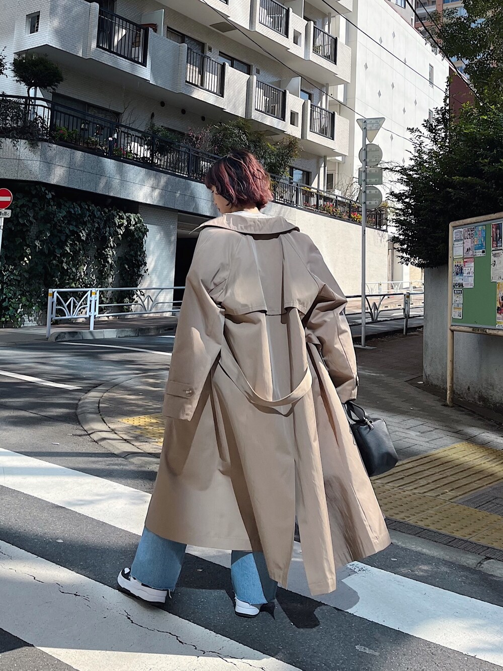 ホワイト系のTシャツ/カットソー、ベージュ系のステンカラーコート、ブラック系のバッグを着用したレディースの春コーディネートの4枚目の写真