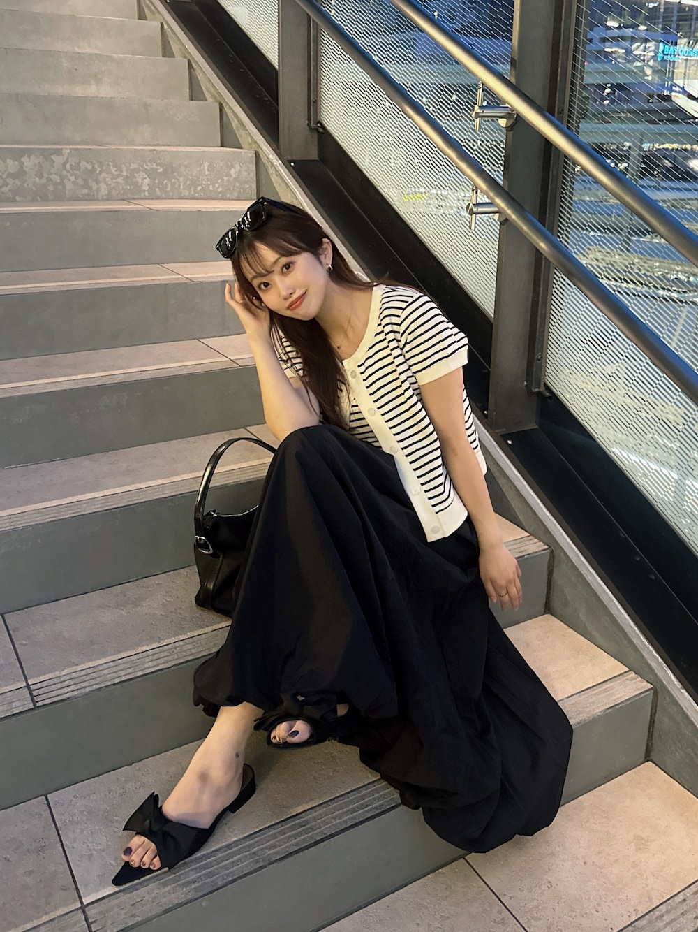 ブラック系のスカート、ブラック系のサンダルを着用したレディースの春コーディネートの1枚目の写真