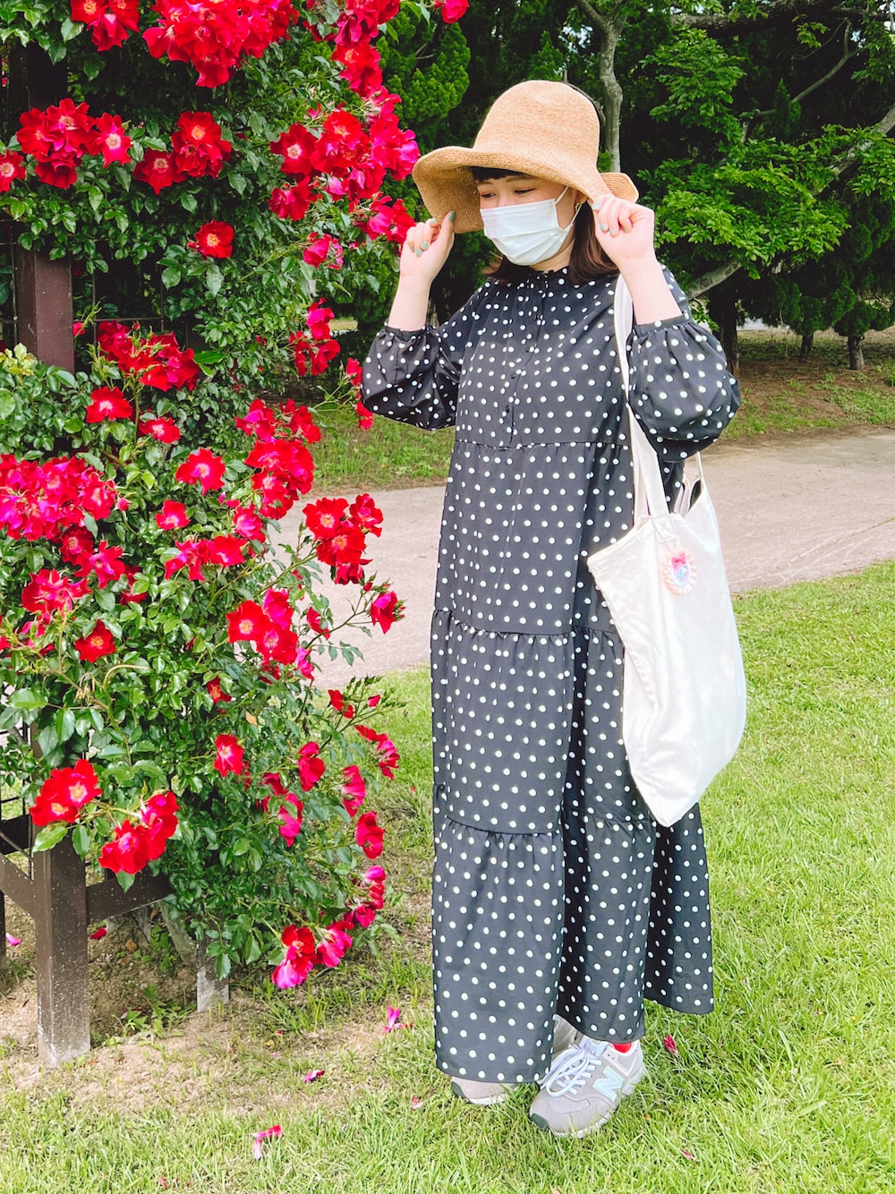 ブラック系のワンピース、ホワイト系のトートバッグ、グレー系のスニーカーを着用したレディースの春コーディネートの1枚目の写真