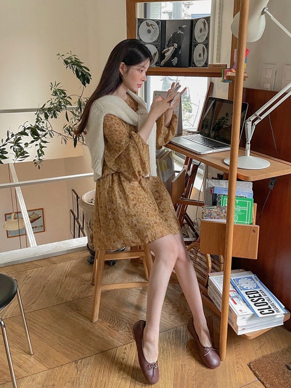 イエロー系のワンピース、ホワイト系のカーディガン/ボレロを着用したレディースの秋コーディネートの1枚目の写真